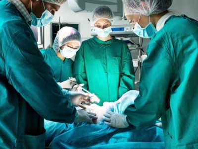 Surgery team operating on anatomical specimen in a tissue bank surgical training facility